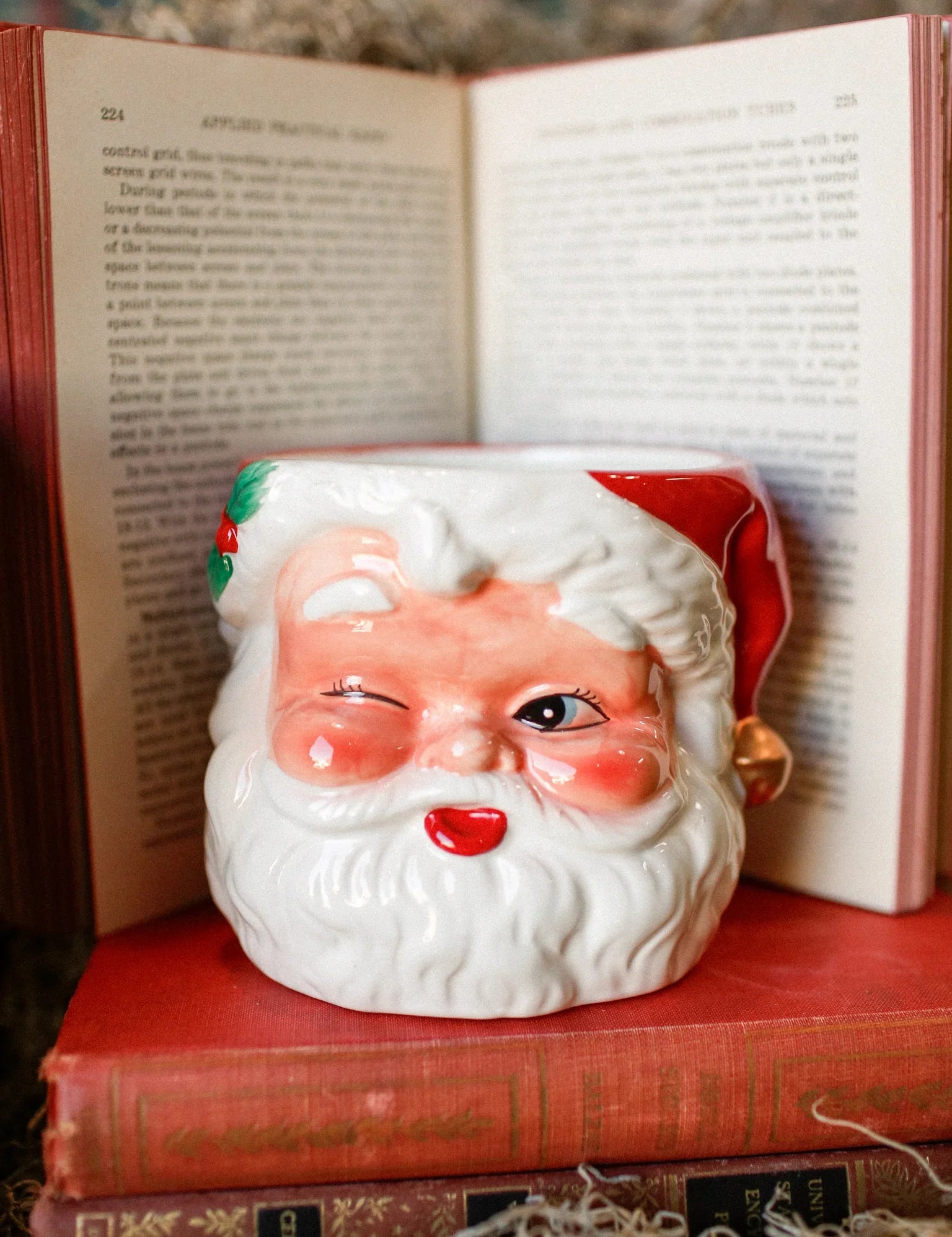 Handcrafted Santa Claus candle resting on vintage books